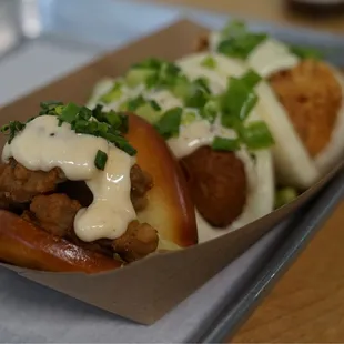 two hot dogs with cheese sauce and green onions