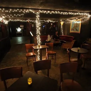 a dimly lit room with tables and chairs