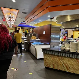 a woman with red hair standing in front of a counter