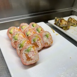 a plate of sushi rolls and a plate of broccoli