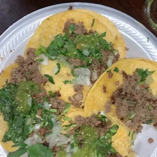three tacos on a paper plate