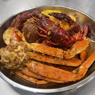 crab legs, corn and potatoes in a bowl