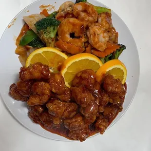 a plate of food with shrimp, broccoli and orange slices