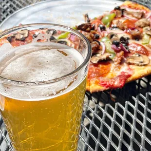 a half eaten pizza and a glass of beer