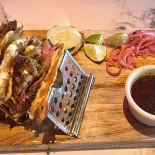 Birria tacos, pickled onion, salsas and consomé.