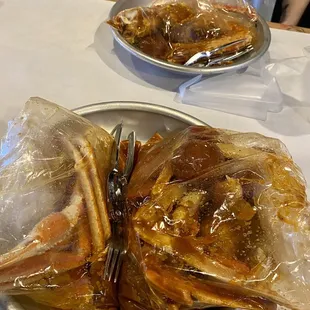 two plates of food wrapped in plastic