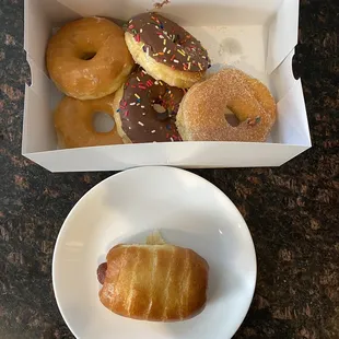 a box of doughnuts and a plate of doughnuts