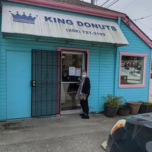 a man standing outside of a blue building