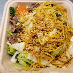 a takeout container with noodles and meat