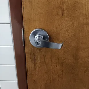 Bathroom stall door handle remained half down not locked.
