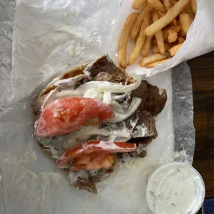 Lamb gyro with onion, tomato &amp; tzatziki sauce with a side of crunchy French fries!  Delicious
