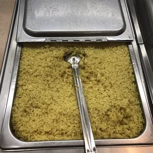 a tray of rice with a spoon sticking out of it