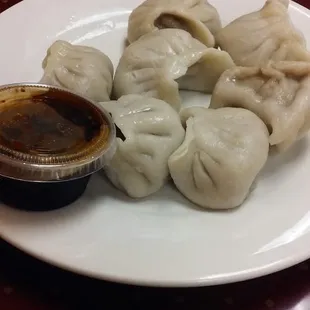 a plate of dumplings and dipping sauce