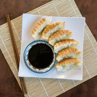 a plate of dumplings with dipping sauce
