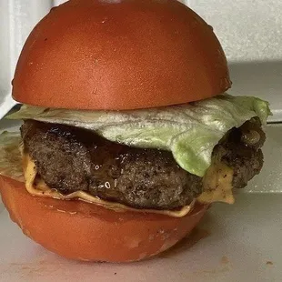 The Shogun  tomato buns, square cut lettuce, cheddar cheese, pineapple slice, topped with teriyaki sauce and caramelized onions