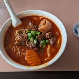a bowl of soup with meat and vegetables