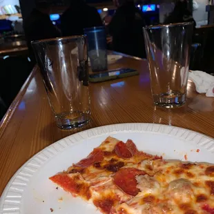 a slice of pizza on a paper plate