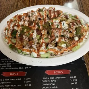 Chicken Bowl comes with chicken over rice mixed in with cucumber salad and topped with tzatziki and chutney sauce and spice powder