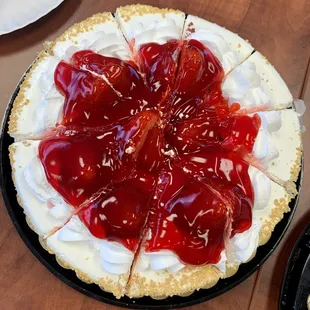 a pie with whipped cream and cherry sauce