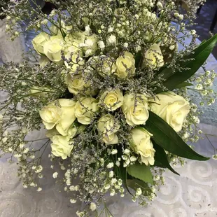 a bouquet of white roses and baby's breath
