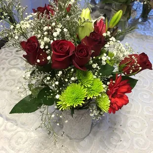 a bouquet of red roses and green carnations