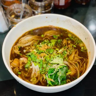 a bowl of noodles with meat and vegetables