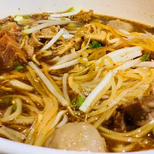 a bowl of noodles with meat and vegetables