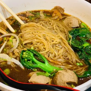 a bowl of noodles with meat and vegetables