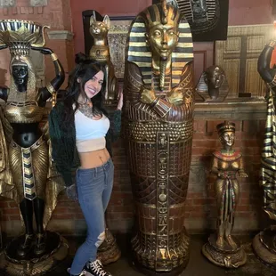 a woman standing in front of egyptian statues