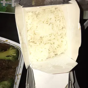 a container of rice and broccoli