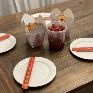 a table with plates, cups, and chopsticks