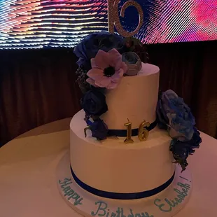 a white cake with blue and purple flowers