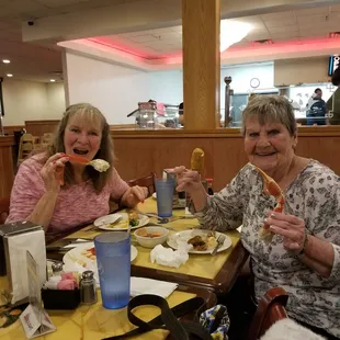 two women sitting at a table eating food