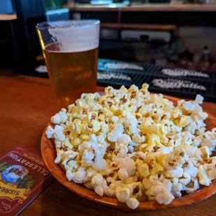 a bowl of popcorn and a pint of beer
