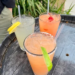 three cocktails on a barrel