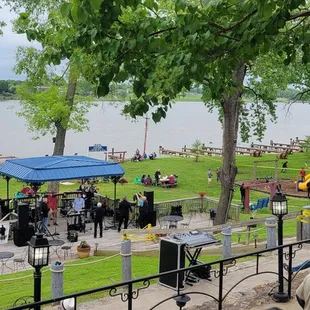a crowd of people sitting at tables in a park