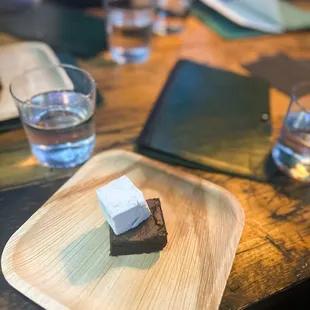 a piece of brownie on a wooden plate