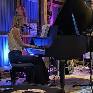 a woman playing a grand piano
