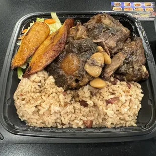 Oxtail with veggies, rice and plantains.