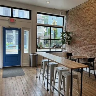 tables and stools in front of large windows