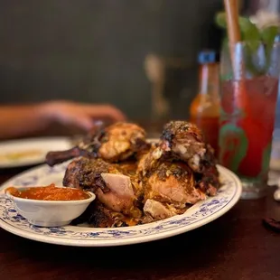 a plate of chicken wings with a side of sauce