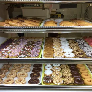 a variety of doughnuts in a display case