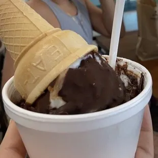 a person holding a cup of ice cream