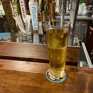 a glass of beer on a bar