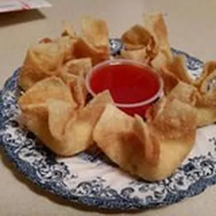 a plate of wontons with dipping sauce