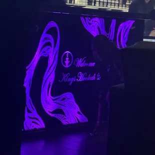 a woman standing in front of a neon sign