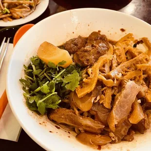 a bowl of noodles with meat and vegetables