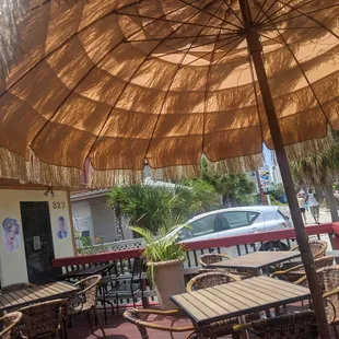a patio with tables and chairs and an umbrella