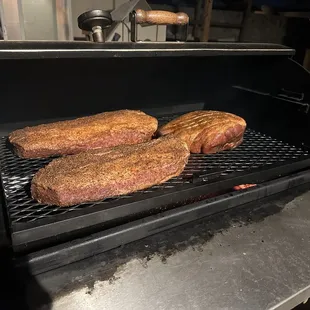 steaks being cooked on a grill