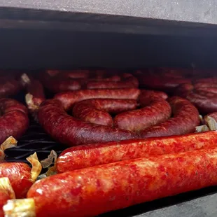 a bunch of sausages cooking on a grill